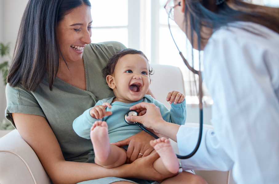 A mother and baby smiling at a doctor