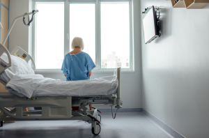 a woman sitting on a hospital bed facing away from the camera