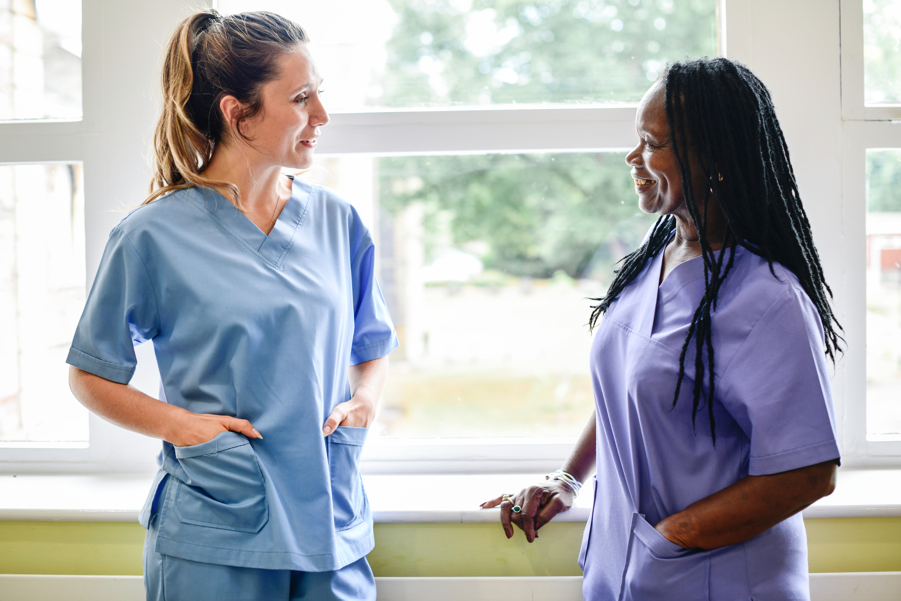 two nurses talking in a hallway